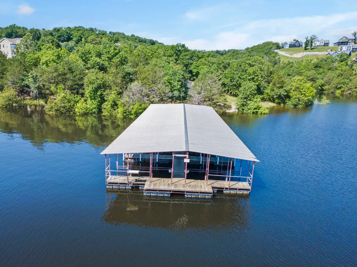 A serene dock scene surrounded by trees and calm water, inviting peaceful moments of relaxation, fishing, or watching sunsets. The dock is nestled in nature, providing direct access to outdoor adventures.